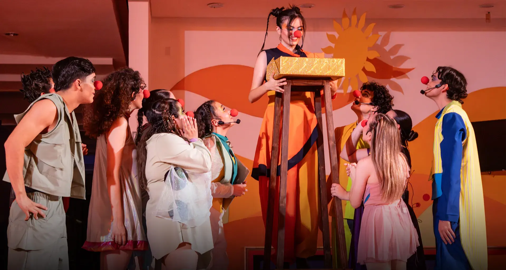 Actores con vestuarios y narices de payaso.