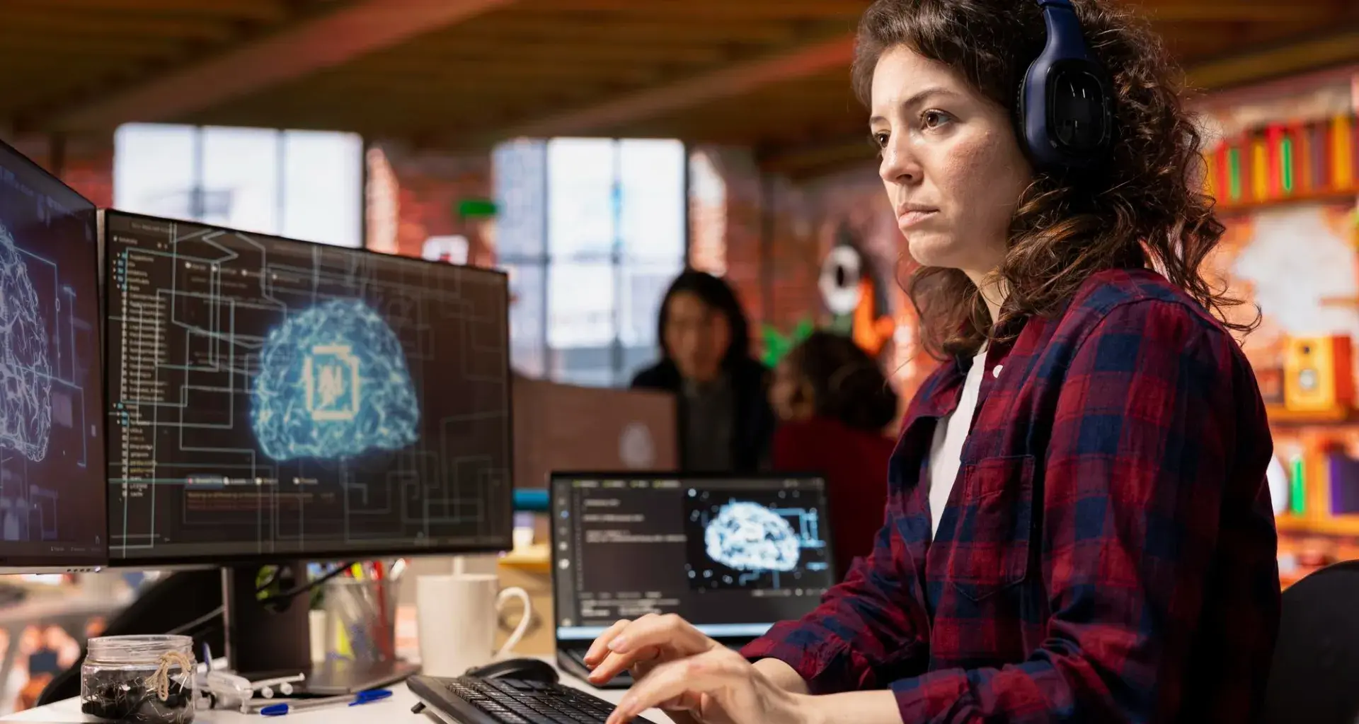 estudiante universitaria con audifonos viendo varias pantallas 