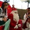 Niño acercándose a Santa Claus y duendes 