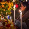 Mujer frente a ofrenda del Día de Muertos