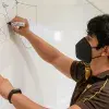 Christian Barush dibujando un triciclo en un pizarrón