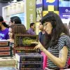 Una mujer leyendo "Los grandes iniciados" durante la Feria Internacional del Libro 2022.
