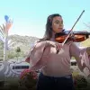 Mariana Páez tocando la viola frente a una vista de la Cápsula del Tiempo del campus Sonora Norte