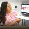 María Guadalupe Córdova sostiene en sus manos una computadora que muestra en pantalla el logo del MIT.