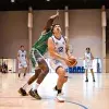 Jugador de Borregos Laguna con uniforme blanco disputa un enceste de básquetbol contra un atleta que viste jersey verde