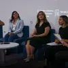 5 mujeres sentadas en sillones azules platicando