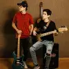 Hermanos posan con guitarra y bajo en espacio musical del Tec de Monterrey