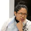 Profesora con lentes, ropa blanca y el cabello sujetado