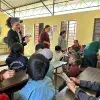 alumnos sentados en escritorios viendo lección