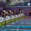 Competidores de natación preparandose para iniciar la carrera.