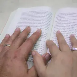 Manos sobre un libro de texto.