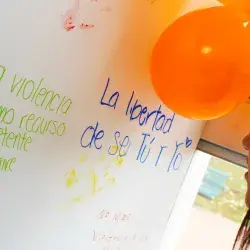 Mujer frente a un mural del Orange Day