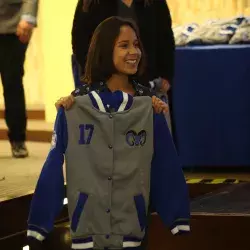 Estudiante recibiendo la chamarra de reconocimiento