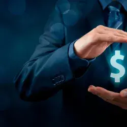 Hombre con signo de pesos entre sus manos, simulando cuidado de finanzas personales
