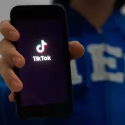 Persona enseñando su celular con la pantalla de inicio de la aplicación de TikTok.