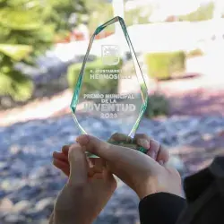 Manos sosteniendo un Premio Municipal a la Juventud