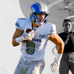 Ayner Hernández, jugador de futbol americano de Borregos Laguna usa jersey blanco y corre con el ovoide