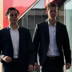 Dos alumnos con vestimenta formal caminando