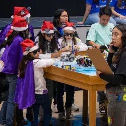 Niñas con gorro navideño y lentes participan en el juego del robot de FIRST LEGO League en PrepaTec Laguna