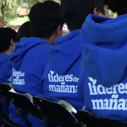Estudiantes beneficiarios de becas de espaldas en evento