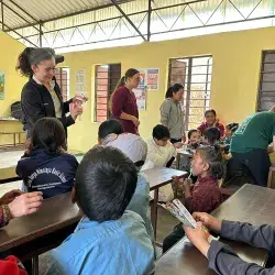 alumnos sentados en escritorios viendo lección