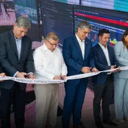 8 personas cortando un listón. 