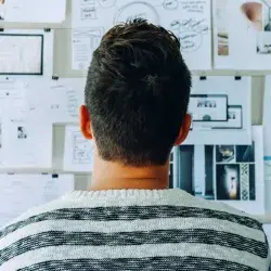 Joven ante un muro de diagramas y planeación