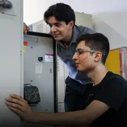 Dos estudiantes analizan los circuitos de una caja.