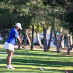Jugadora preparando su tiro en uno de los hoyos del recorrido.