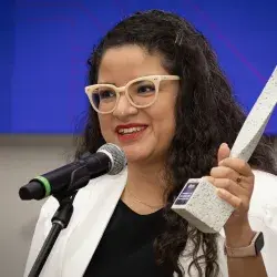 Mujer hablando y en la mano sostiene estatuilla del Premio Mujer Tec 2025.