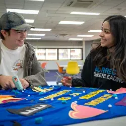 Dos alumnos sonriendo y mirándose.