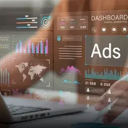 Closeup de una laptop y un cuerpo humano sentado frente a ella, con gráficas semitransparentes superpuestas que muestran métricas de publicidad.