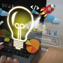 fotografía de una computadora con ilustraciones de bombilla de luz, cohete, ideas