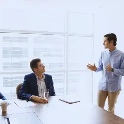 Emprendedor presentando su negocio a inversionistas en reunión para levantar capital