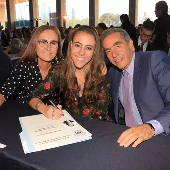 Alumna firmando su título.