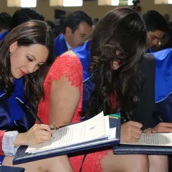 alumna firmando título