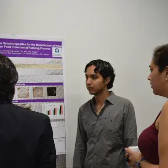 Marcelo Martínez presentando su poster al profesor Rogelio Soto y Adriana Canseco