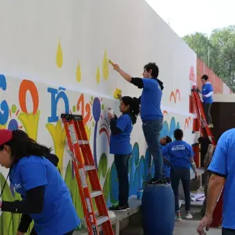 Trabajando en equipo para pintar el mural de la escuela 