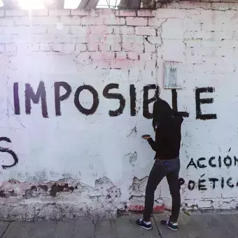 Alumnos y Armando Alanís pintando paredes con frases poéticas