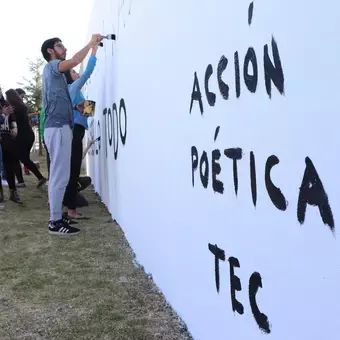 Alumnos y Armando Alanís pintando paredes con frases poéticas