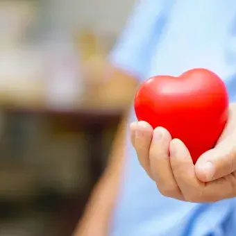 Manos de un médico sosteniendo una figura de corazón para representar la solidaridad en tiempos de COVID-19