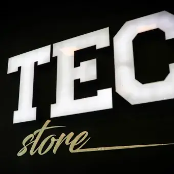 Letrero blanco "TECstore" en muro negro a la entrada de la tienda 
