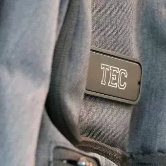 Mochila gris opaca con logo Tec en el centro