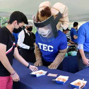 Alumno tomando su orden de chilaquiles en el 78 aniversario del Tec de Monterrey, campus Monterrey