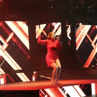 Alumna con vestido rojo cantando