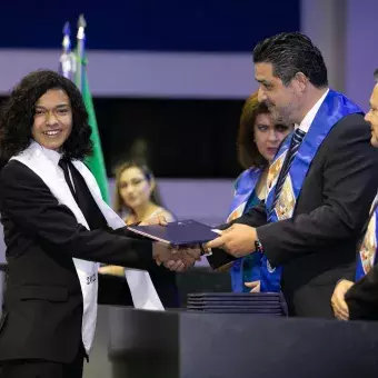 Eric Pascual entregando reconocimiento al alumno Genaro Acosta