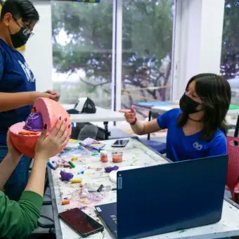 Alumnos pintando una escultura