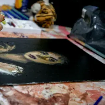 Estudiante pintando una mujer seria