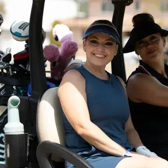 Golfistas mujeres sonriendo en un carro del golf