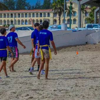 grupo de alumnos haciendo deporte en playa miramar